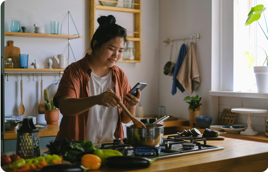 https://www.pexels.com/photo/woman-using-a-phone-while-cooking-in-a-kitchen-12673803/